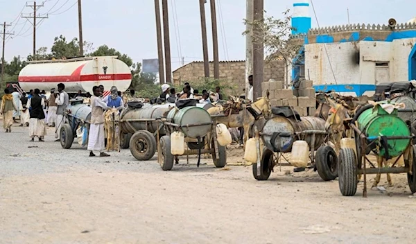 People refill donkey-drawn water tanks during a water crisis in Port Sudan in the Red Sea State of war-torn Sudan on April 9, 2024. (AFP)