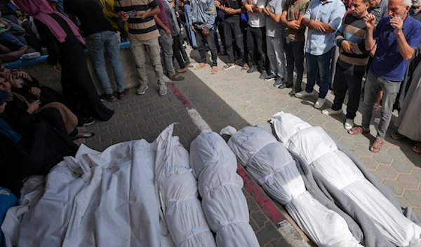 Mourners pray over the bodies of Palestinians who were killed in an Israeli airstrike in Nuseirat, at the al-Aqsa hospital in Deir al-Balah, Gaza Strip, Sunday, May 19, 2024. (AP)