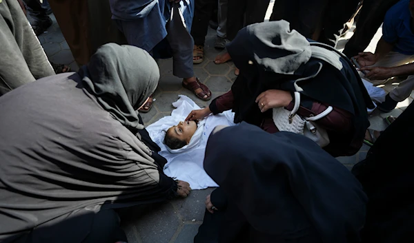 Palestinian women mourn a child killed in the Israeli bombardment of the Gaza Strip outside a hospital in Deir al Ballah on June 5, 2024. (AP)