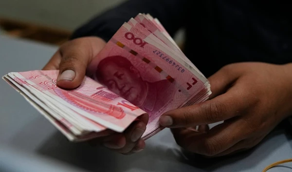 A money exchange shop worker counts Chinese yuan banknotes in La Paz, Bolivia, Wednesday, July 26, 2023. (AP)