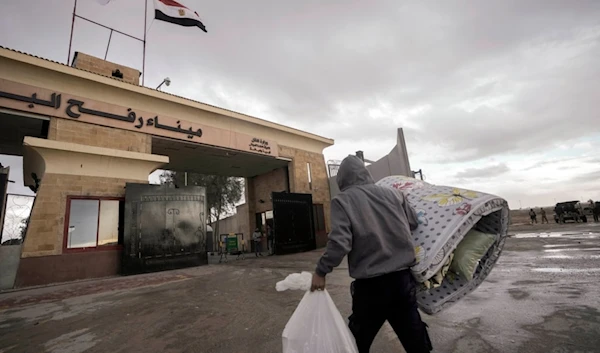 A Palestinian in Egypt waits to cross Rafah crossing to the Gaza Strip at Rafah, Egypt, as a temporary ceasefire went into effect, Monday, Nov. 27, 2023. (AP)