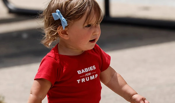 A baby runs before Republican presidential candidate former President Donald Trump speaks at a campaign event Tuesday, June 18, 2024, in Racine, Wis. (AP)