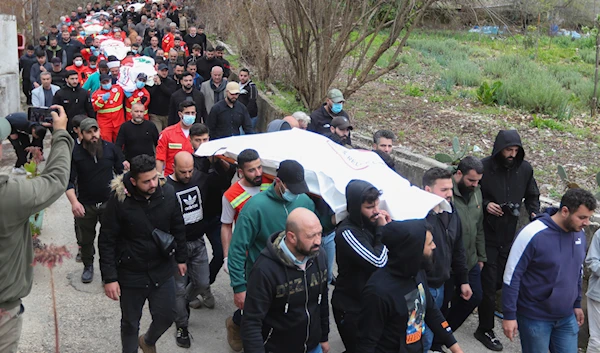 People carry the coffins of paramedics who were killed in an Israeli airstrike, during a funeral procession in Hebbariye village, south Lebanon, March 27, 2024 (AP)