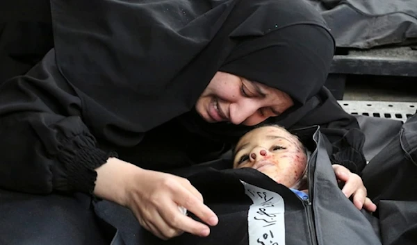 A Palestinian woman mourns a child killed in the Israeli bombardment of the Gaza Strip, occupied Palestine at a morgue in Khan Younis, Tuesday, February 27, 2024. (AP)