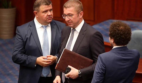 Hristijan Mickoski, center, the leader of the center-right VMRO-DPMNE party and prime minister-designate, walks in during a session in the parliament building in Skopje, North Macedonia, late on June 23, 2024. (AP)