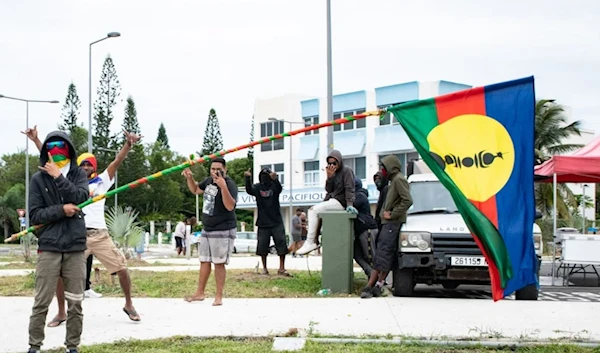 A pro-independence supporter holds a flag of the Kanak and Socialist National Liberation Front (FLNKS) during a rally in support of the independence activists who were arrested. (AFP/Getty Images