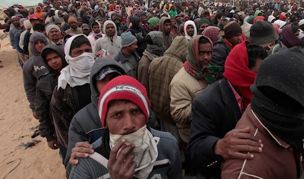 Migrant wait in line for food at a refugee camp on the Tunisia-Libyan border, in Ras Ajdir, Tunisia,on March 12, 2011. (AP)