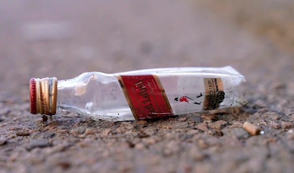 An empty miniature bottle that once contained liquor rests on a street near a sidewalk, Monday, April 3, 2023, in Boston. (AP)