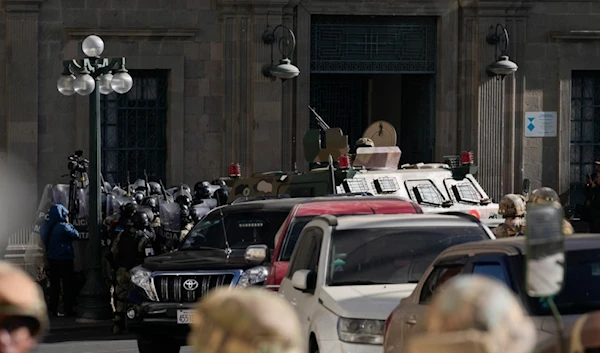 Military Police gather outside the main entrance as an armored vehicle rams into the door of the presidential palace in Plaza Murillo in La Paz, Bolivia, Wednesday, June 26, 2024. (AP)