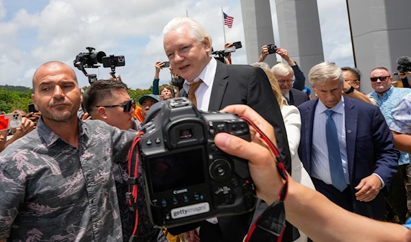 WikiLeaks founder Julian Assange, centre, is escorted to a vehicle as he leaves the federal court in Saipan, Mariana Islands, June 26, 2024 (AP)