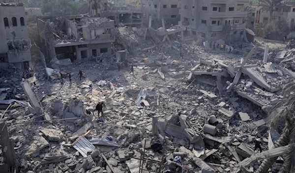 Palestinians look at destruction by the Israeli bombardment of the Gaza Strip, in Deir al Balah, occupied Palestine, Wednesday, November 22,2023. (AP)