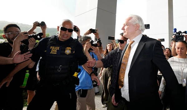 WikiLeaks founder Julian Assange, right, arrives, surrounded by the the media, at the United States courthouse where he is expected enter a plea deal, in Saipan, Mariana Islands, Wednesday, June 26 2024 (AP Photo/Eugene Hoshiko)