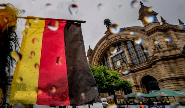 A small German national flag waves in front of the central train station in Frankfurt, Germany, on a rainy Wednesday, June 19, 2024. (AP Photo/Michael Probst)