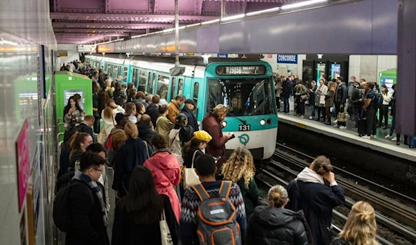 People wait for a train at the Concorde metro station in Paris, France, Tuesday, Oct. 17, 2023. (AP Photo/Pavel Golovkin)