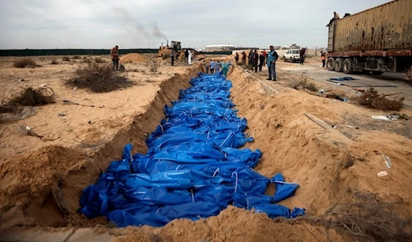 Palestinians bury families killed in the Israeli bombardment who were brought from al-Shifa hospital, in a mass grave in the town of Khan Younis, southern Gaza Strip, Wednesday, Nov. 22, 2023. (AP)