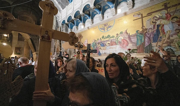 Orthodox Christians walk the Way of the Cross procession that commemorates Jesus Christ's crucifixion on Good Friday, inside the Church of the Holy Sepulchre in the Old City of occupied al-Quds, May 3, 2024 (AP)