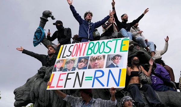 A protester holds an anti-far right banner showing the faces of French Presidents and the word 'Honte' or 'Shame' during a rally in Paris, Saturday, June 15, 2024. (AP)