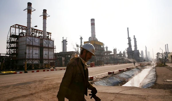 In this Dec. 22, 2014 file photo, an Iranian oil worker makes his way through Tehran's oil refinery south of the capital Tehran, Iran. (AP)