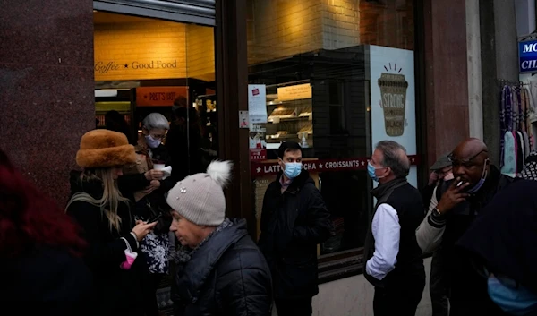 People wearing face masks to curb the spread of coronavirus queue outside a branch of the Pret a Manger sandwich chain in central London, Tuesday, Jan. 11, 2022. (AP)