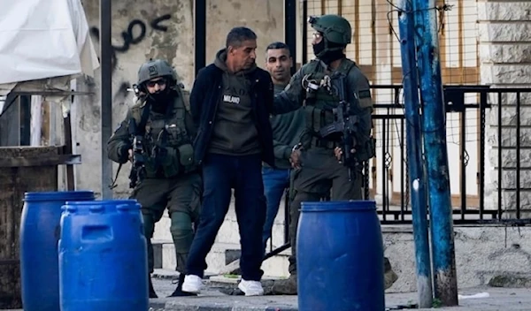 Illustrative: IOF arrest two Palestinian men during a military raid in the Askar refugee camp near Nablus on December 31, 2023. (AP)