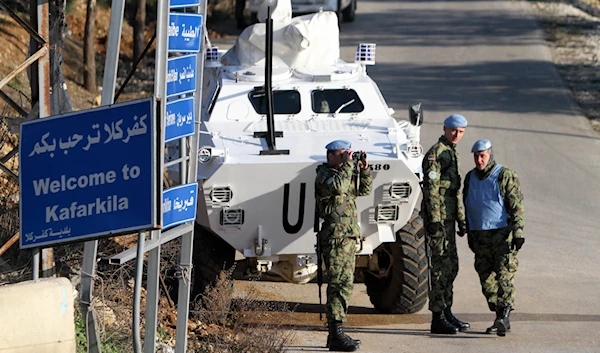 A Serbian U.N. peacekeeper looks through binoculars to monitor the border with Israel while standing next to an armored vehicle, during a patrol of the Lebanese-Israeli border, in the southern village of Kfar Kila, Lebanon, on January 19, 2015. (AP)