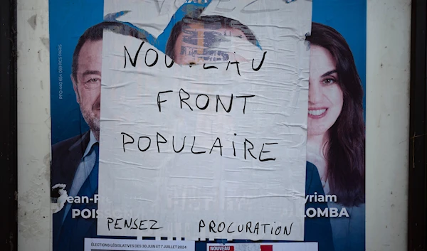 An electoral campaign board is set up in the countryside for the upcoming parliamentary elections, in Lachassagne, central France, June 25, 2024. (AP)