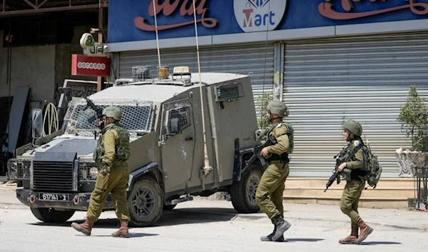 Israeli occupation officers walk back to their vehicles in the Palestinians al-Fara'a refugee camp in the occupied West Bank following an IOF military raid, Monday, June 10, 2024. (AP)