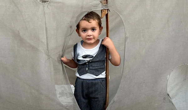 A Palestinian child sheltering on extremely overcrowded land in Deir al-Balah amid Israeli genocide on June 3, 2024. (UNRWA)