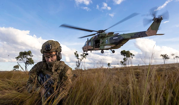 Australian troops dismount from an MRH-90 Taipan during Exercise Chau Pha at Townsville Field Training Area, Townsville, Queensland, on June 12, 2023 (AP)