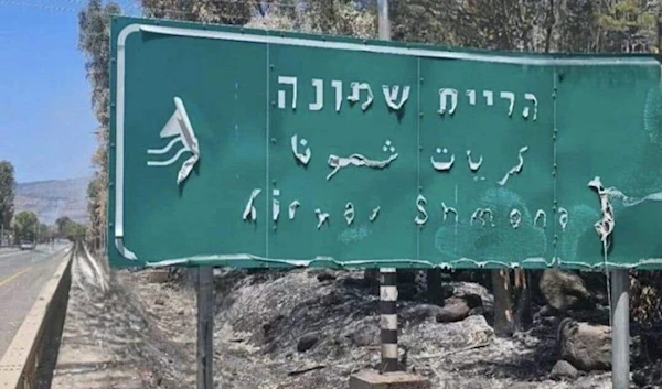 Sign on the entrance of Kiryat Shmona melting away amid intense fires caused by Hezbollah's drones (Social Media)