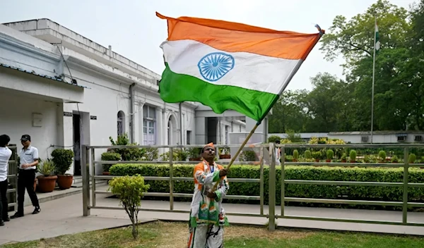 A supporter of Indian National Congress (INC) party waves India's national flag after counting of votes began for India's general election, at the INC headquarters in New Delhi [AFP]