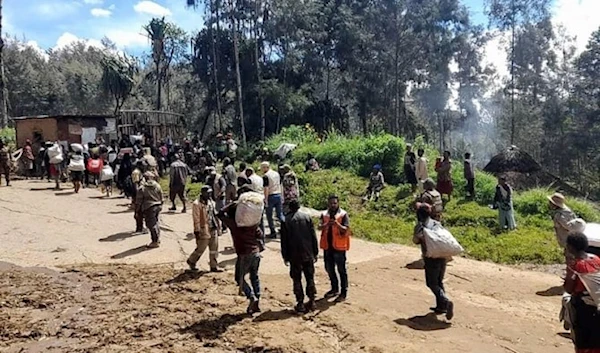 Above, locals carry supplies at the site of a landslide at Yambali village in the region of Maip Mulitaka, in Papua New Guinea’s Enga Province on May 29, 2024. (AFP)