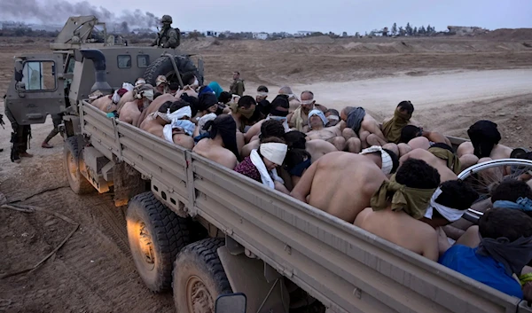 Israeli occupation forces next to a truck packed with bound and blindfolded Palestinian abductees, in Gaza in December. (Associated Press)