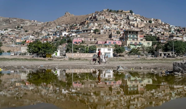 An Afghan traveling salesman poses for a portrait with his bicycle on the outskirts of Kabul, in Afghanistan, Wednesday, June 14, 2023 (AP Photo/Ebrahim Noroozi)