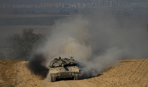 Israeli soldiers drive a tank near the Gaza Strip, in southern occupied Palestine, June 5, 2024 (AP)