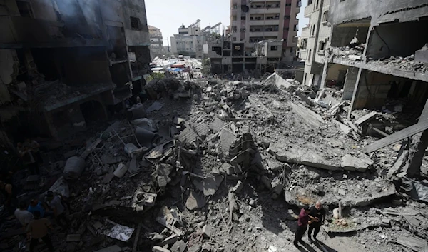 Palestinians look at the aftermath of the Israeli bombing in Nuseirat refugee camp, Gaza Strip, Saturday, June 8, 2024. (AP Photo/Jehad Alshrafi)