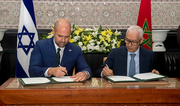 Rachid Talbi Alami, Speaker of the Moroccan House of Representatives, right, signs a bilateral deal with his Israeli counterpart, Amir Ohana, during the latter's visit to Rabat, Morocco, June, 8, 2023 (AP)