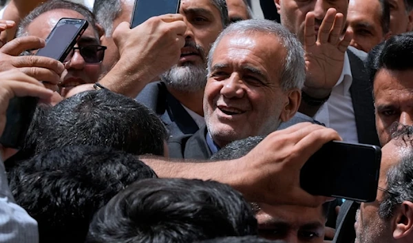 Iranian presidential candidate Masoud Pezeshkian is greeted by his supporters as he arrives to vote at a polling station in Tehran on July 5,2024. (AP)