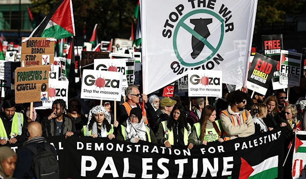 Pro-Palestinian protesters gather with placards and flags, including a banner urging "Resist! Return!, at a 'National March For Palestine' in central London on November 11, 2023 (AFP)