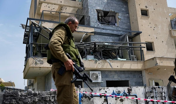 Israeli occupation forces examine the site hit by a rocket fired from Lebanon, in Kiryat Shmona, northern occupied Palestine, Wednesday, March 27, 2024. (AP)