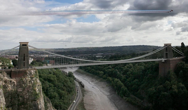 The Red Arrows display over the Clifton Suspension Bridge during the 35th annual Bristol International Balloon Fiesta in Bristol on Friday, Aug. 9, 2013. (AP)