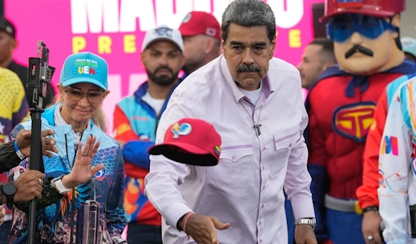 Venezuelan President Nicolas Maduro throws a cap to supporters during a campaign rally in the Boulevard of Coche in Caracas, Venezuela, Monday, July 8, 2024. (AP)