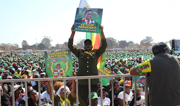 A supporter of Zimbabwean President Emmerson Mnangagwa holds the Zimbabwean flag at a campaign rally in Harare, on August 9, 2023. (AP)