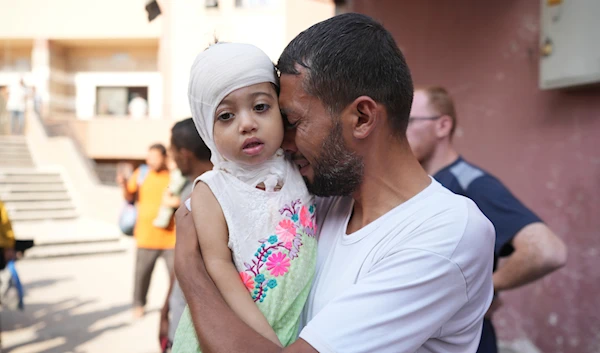 A Palestinian man reacts as he says goodbye to his sick daughter before leaving the Gaza Strip to get treatment abroad through the Kerem Shalom crossing, in Khan Younis, southern Gaza Strip, on June 27, 2024. (AP)