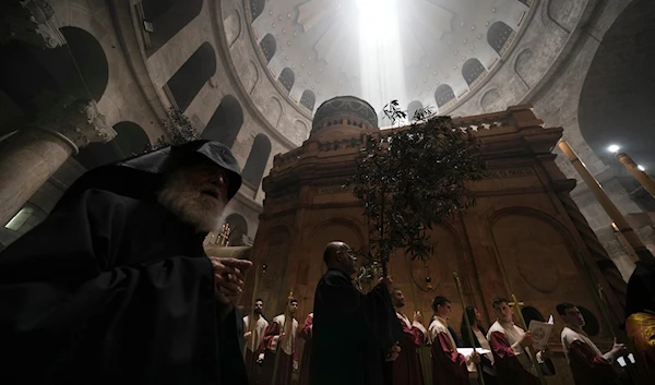 Orthodox Christian clergy marks Palm Sunday at the Church of the Holy Sepulchre, a place where Christians believe Jesus Christ was crucified, buried and resurrected, in al-Quds, on April 17, 2022. (AP)