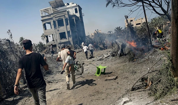 Palestinians evacuate from a site hit by an Israeli bombardment on Khan Younis, southern Gaza Strip, Saturday, July 13, 2024. (AP)