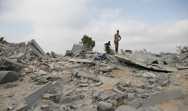 Palestinians look at the destruction after an Israeli airstrike in Khan Younis, Gaza Strip, occupied Palestine, June 3, 2024 (AP)