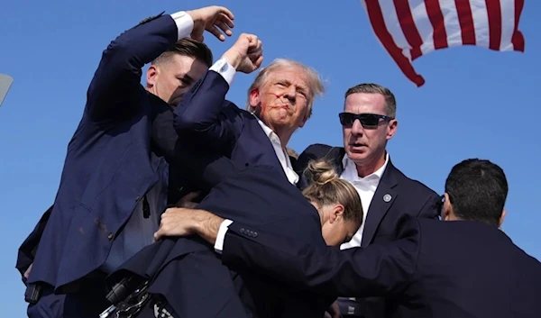 Security evacuate a bloody Donald Trump after he got shot while giving a speech in Pennsylvania, July 14, 2024 (Social Media)