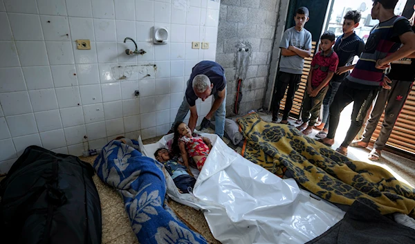 Palestinians check the bodies of their relatives killed in the Israeli bombardment of the Gaza Strip, at a hospital morgue in Deir al-Balah, on July 13, 2024. (AP)