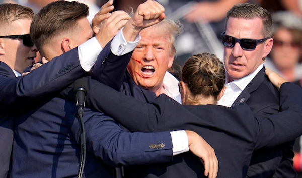 Republican presidential candidate former President Donald Trump is helped off the stage by U.S. Secret Service agents at a campaign event in Butler, Pa., on Saturday, July 13, 2024. (AP)